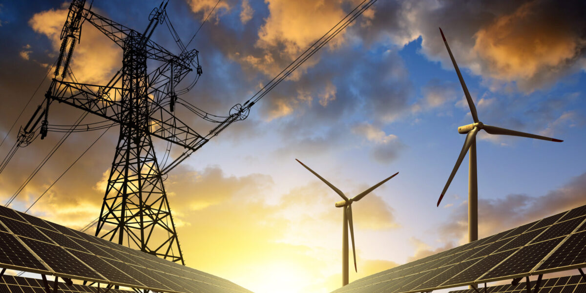 Power lines, wind turbines, and solar panels in a field under a dramatic sunset sky, symbolizing renewable energy and sustainable electricity generation.