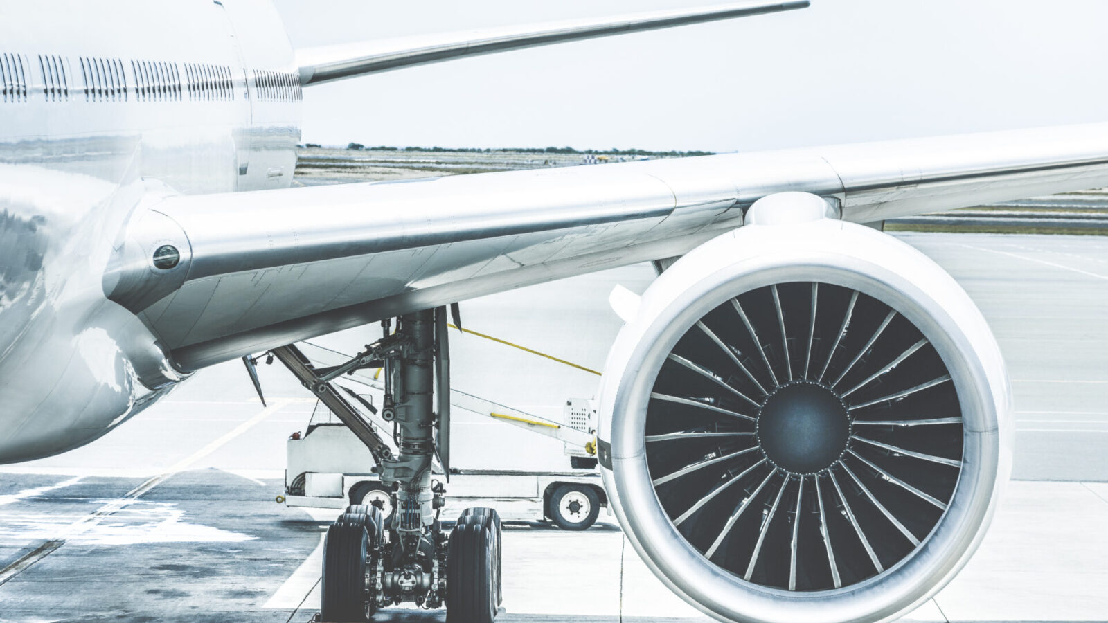 Detail of airplane engine wing at terminal gate before takeoff.