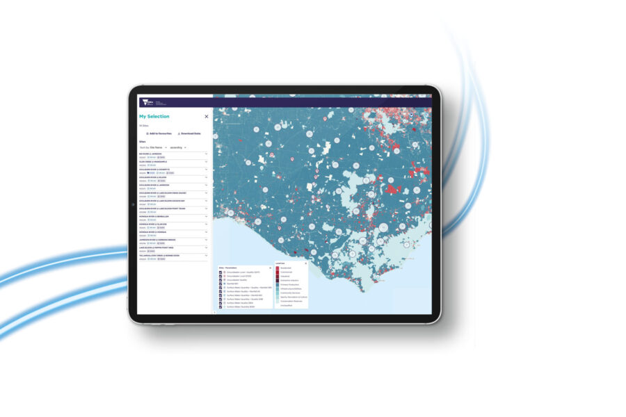 A tablet displays a detailed map with various colored circles and data layers on a data platform, showing geographic and statistical information for Victoria, Australia. Blue lines curve in the background.